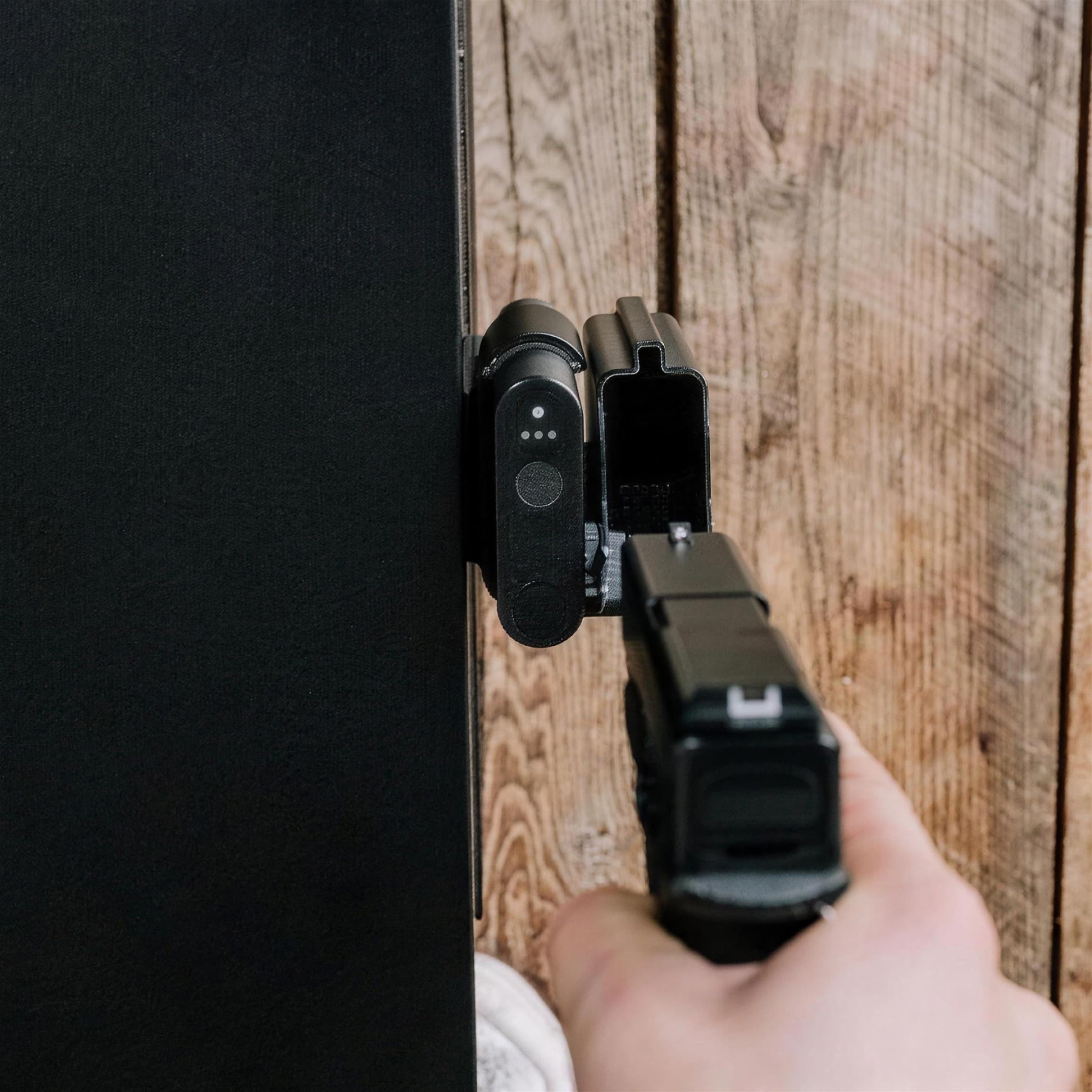 Top view of a pistol seated and locked in a Reach 2S mounted to a wooden surface