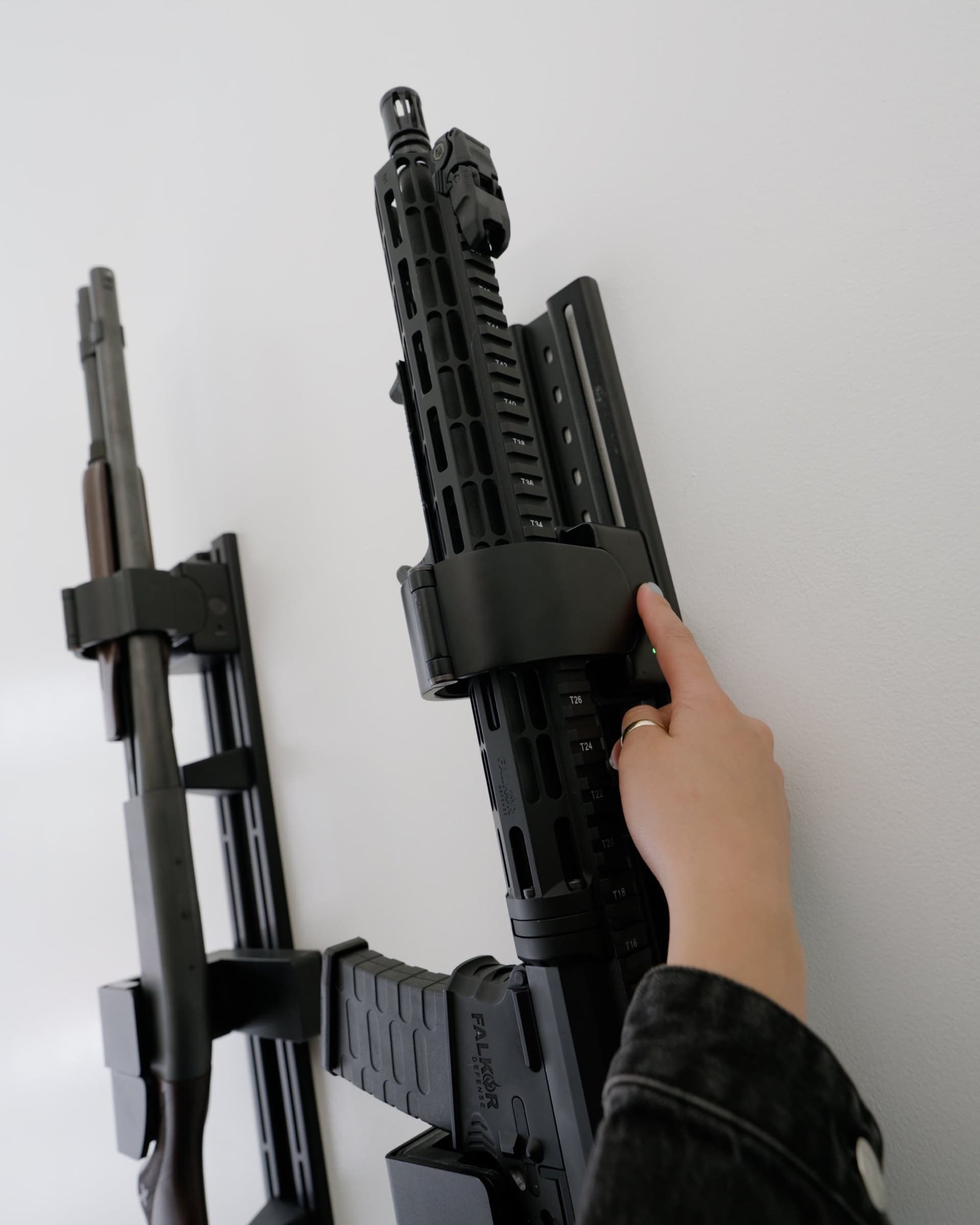 A hand lifting a rifle away from the open RACT barrel lock