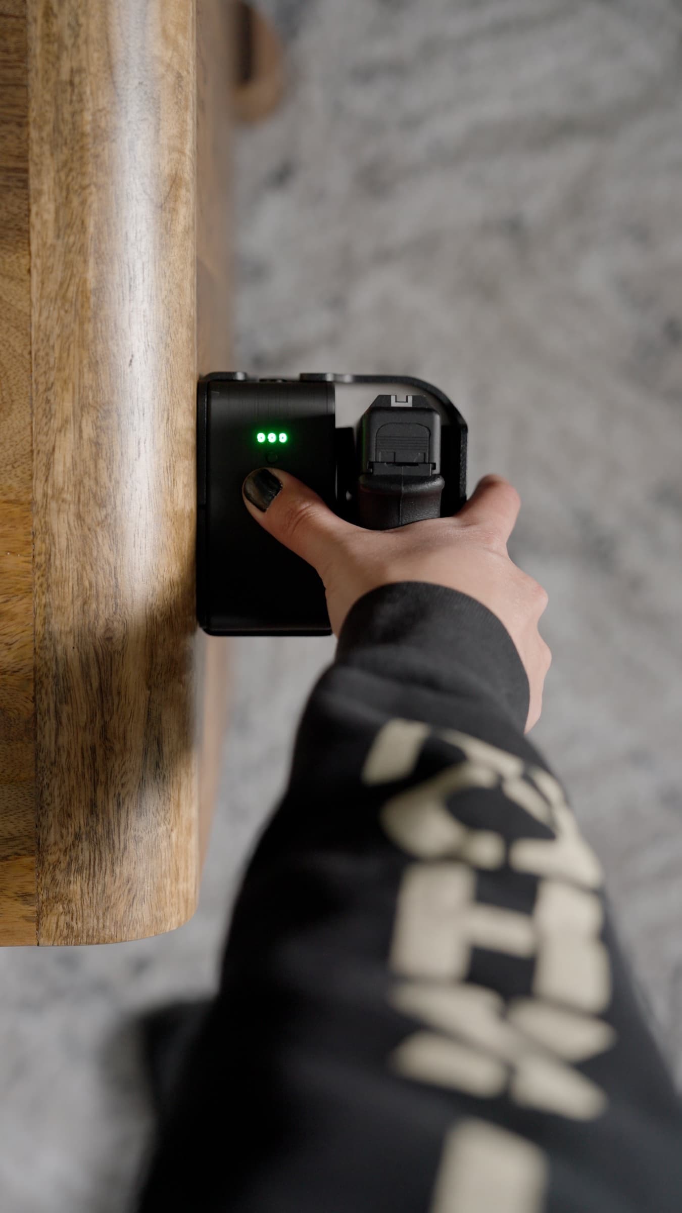 A finger on the fingerprint sensor of a Reach safe, green status lights lit